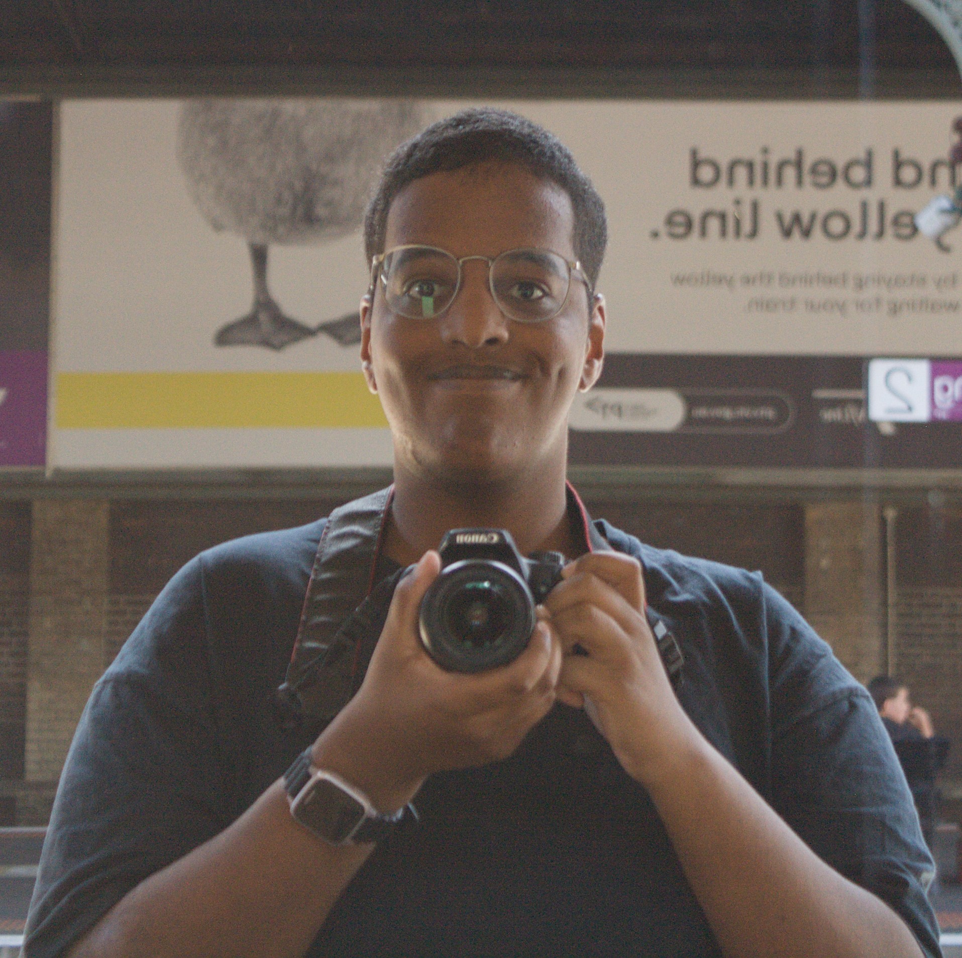 A self-portrait of me capturing myself in a train station mirror.